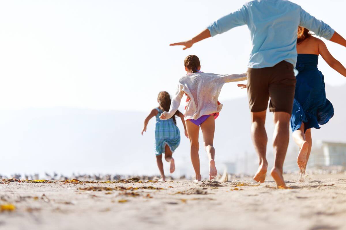 A family of four play around at beach in Montana during their family vacation.
