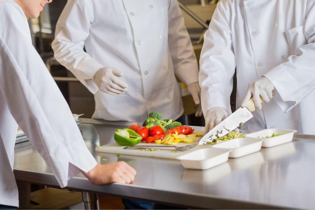 A group of chefs prepare food in a kitchen during a Montana culinary tour.