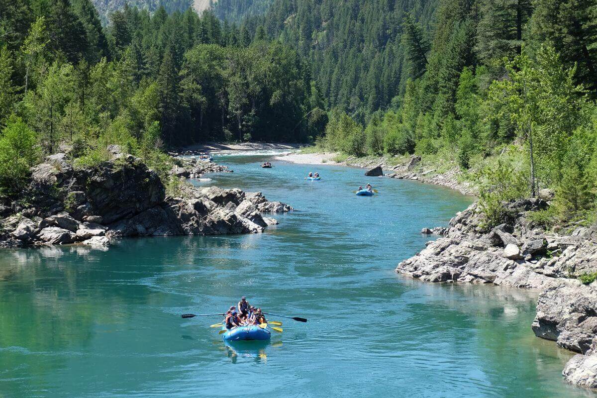 A group of people are enjoying montana vacations by rafting down a river.