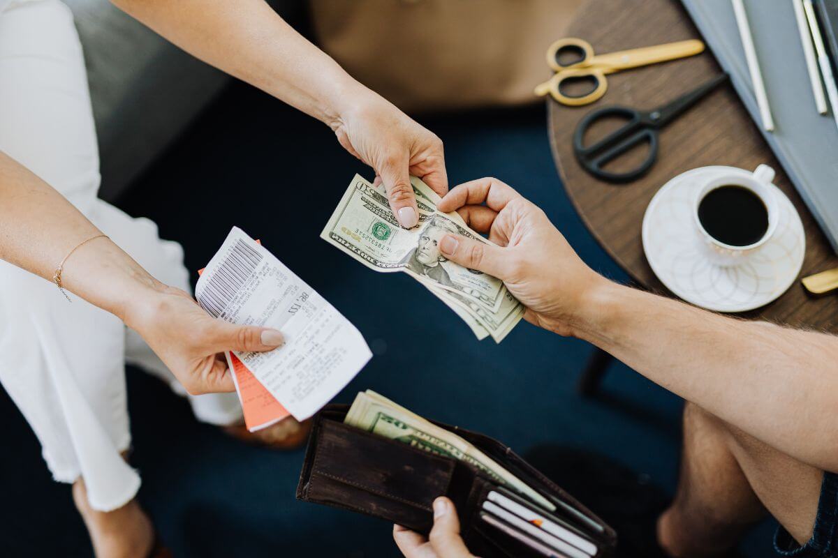 A man handing money to a woman, and the woman giving him his receipt in Montana.