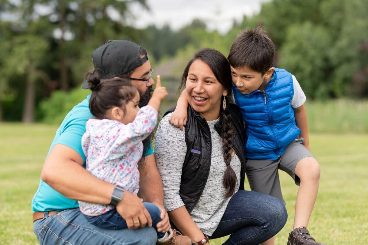 A Native American family sitting on the grass in Montana.