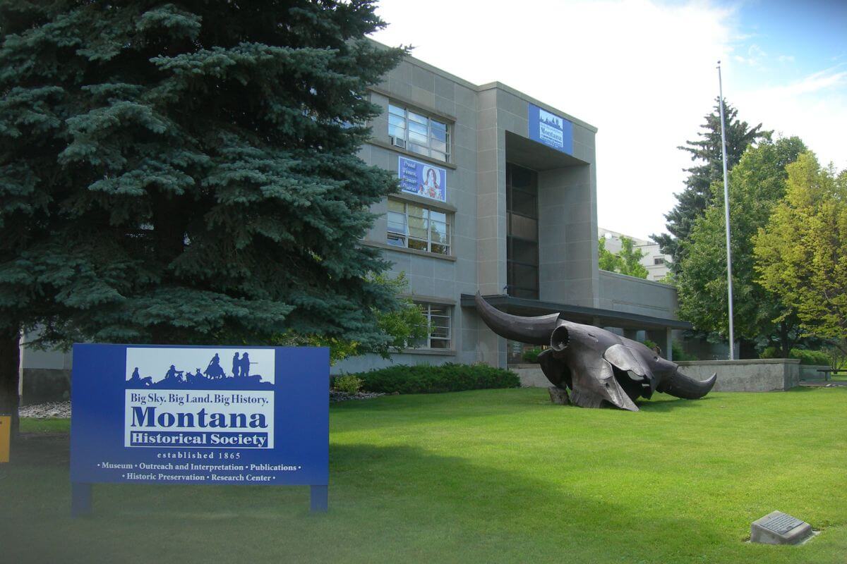 A historical museum with a sculpture in front.