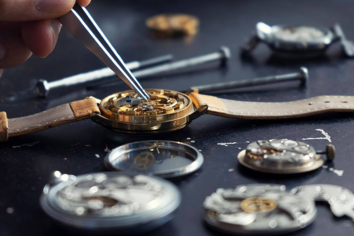 A man is making a watch on a table with Montana gemstones.