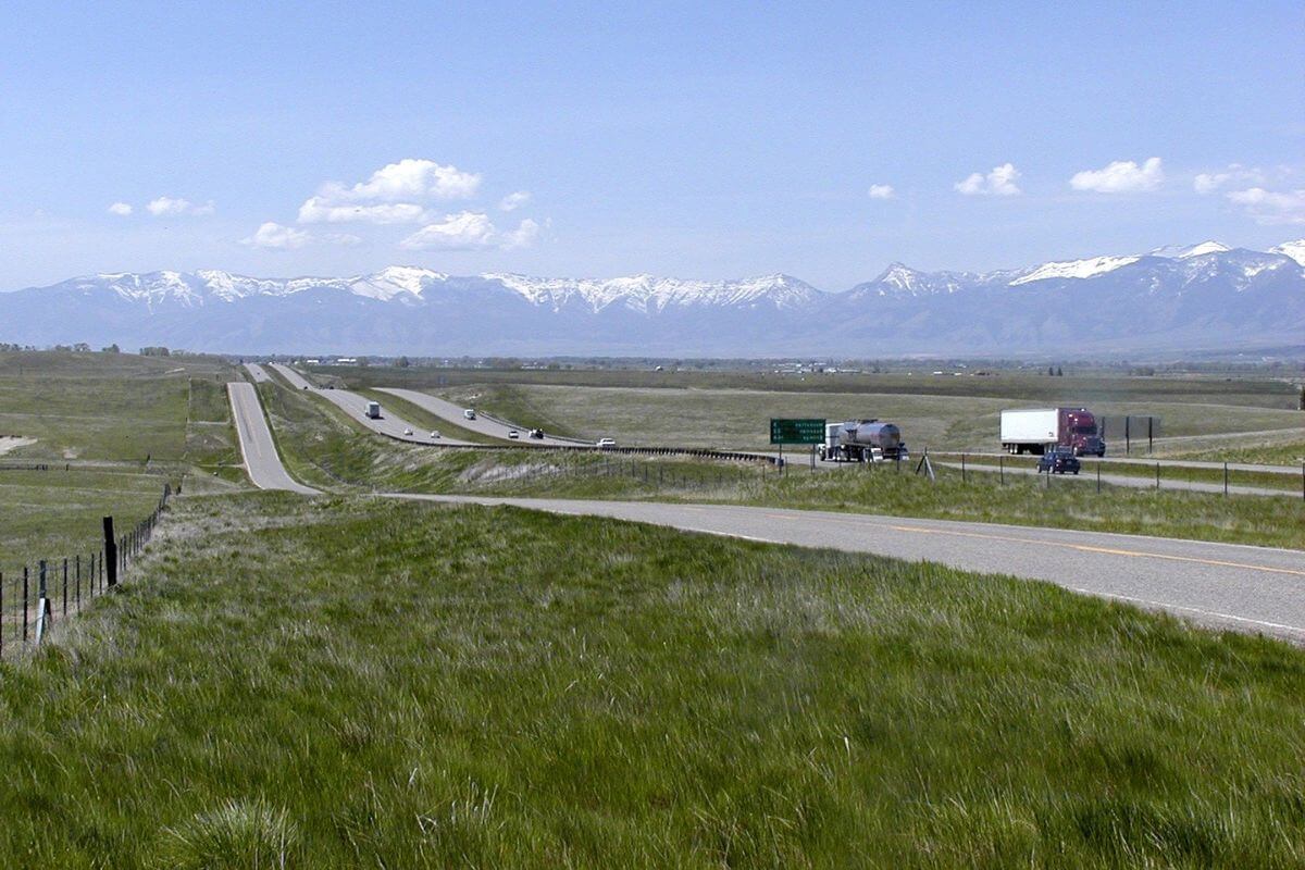 A grassy field next to a highway in Montana.