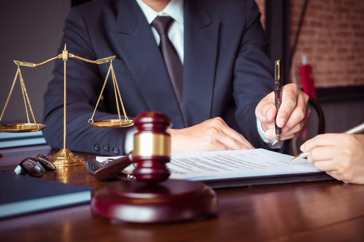 Attorney Presenting a Document Along with a Gavel and Balance Scale