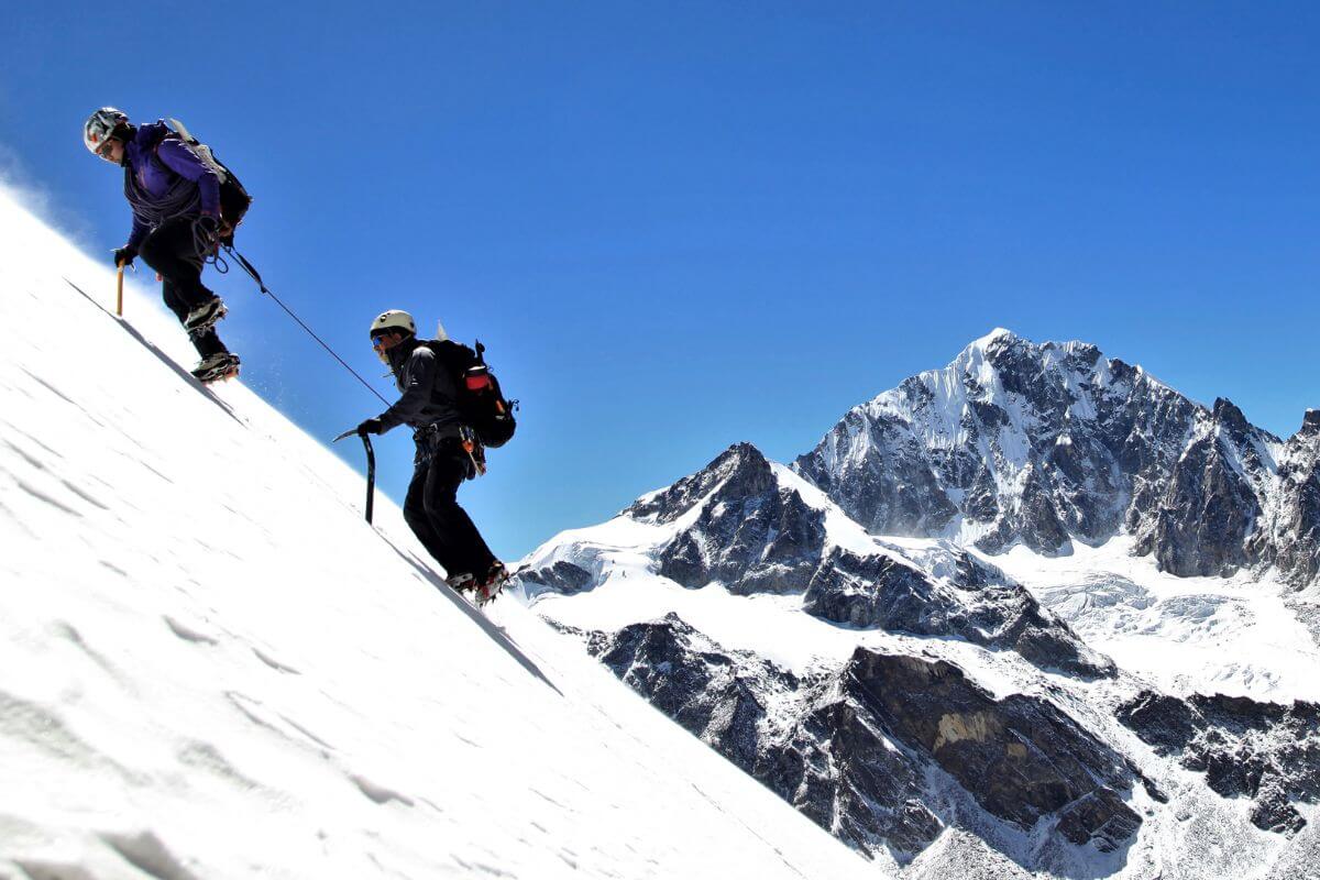 Two people ice climbing on a snowy mountain in Montana.