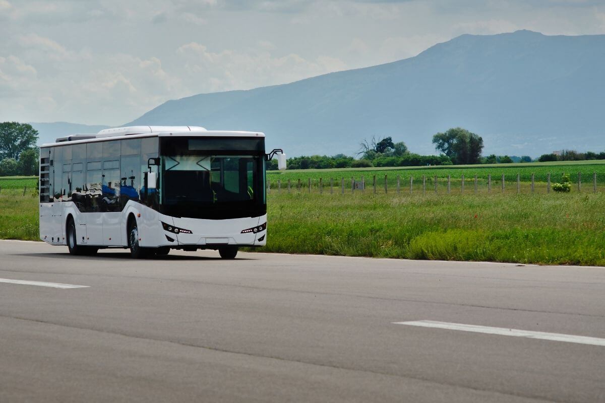 A white bus driving down a road in Montana.