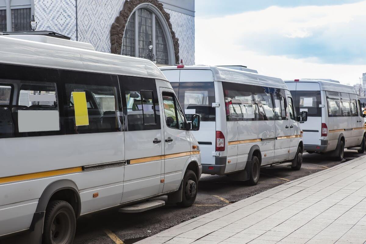 White shuttles parked in a line in a Montana street.